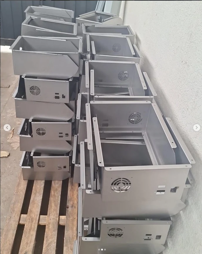 Série de gabinetes metálicos em chapa de aço dobrada, com furação para ventilação e abas de fixação, produzidos na Central do Aço em São José do Rio Preto